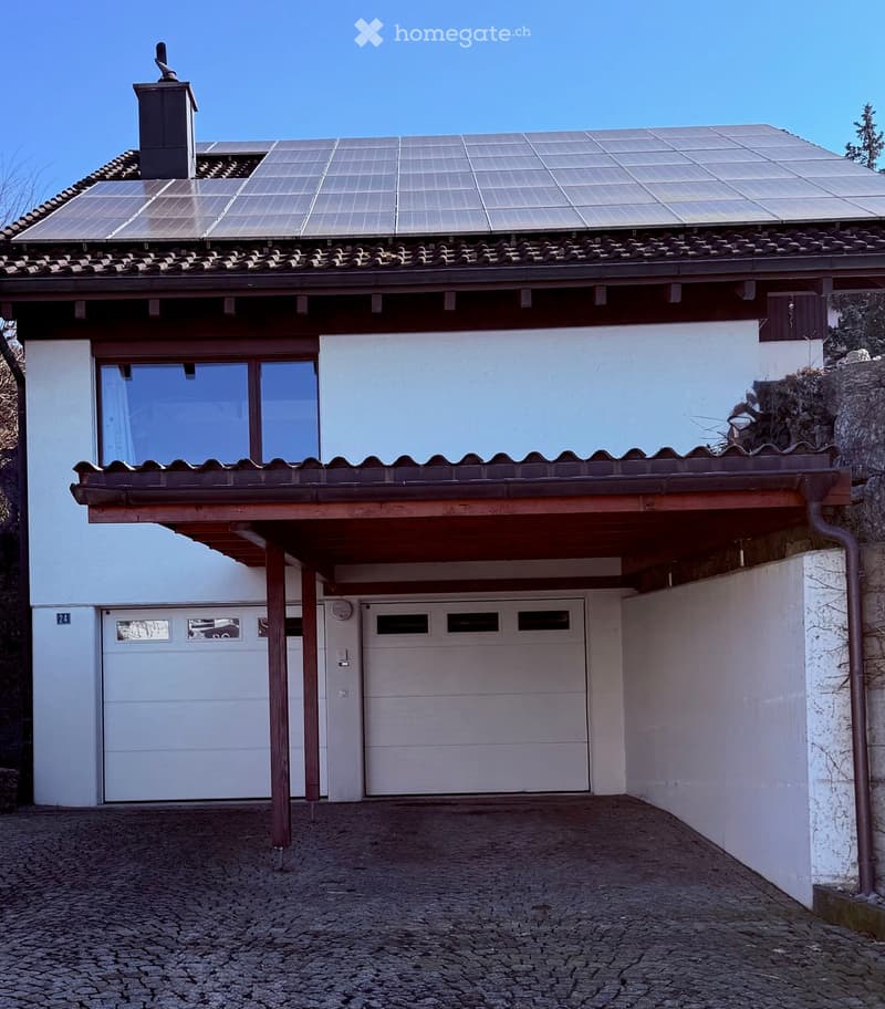 2 story house, white walls, double garage, solar panels on roof, tiled roof