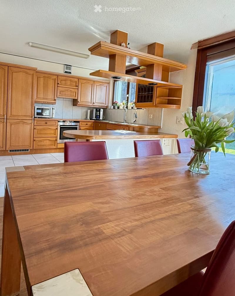 modern kitchen, dining area, wooden table, red chairs, cabinets, open window, wooden flooring