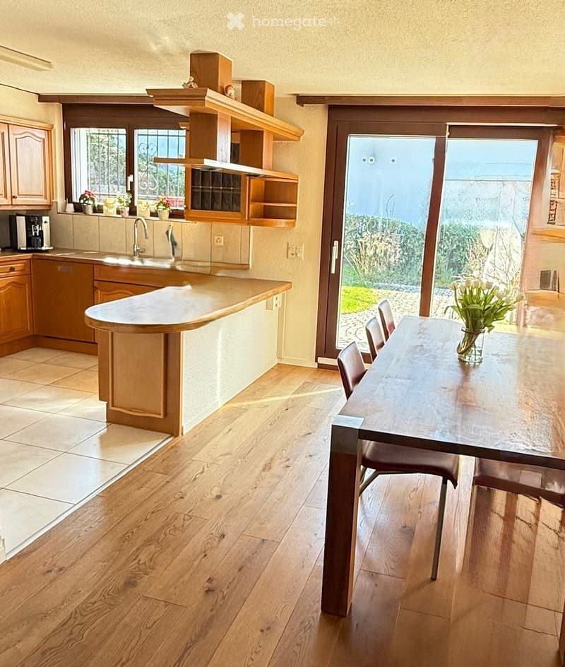 kitchen and dining area, island with countertops, large window with doors to terrace, wooden cabinets, tile floor, wooden table and chairs