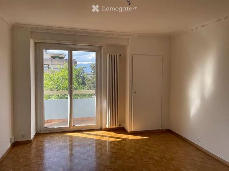 empty room, wooden floor, sliding glass door, white walls, white door, balcony, radiator