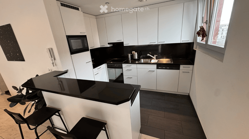 modern kitchen with white cabinets, black countertops, modern appliances, window