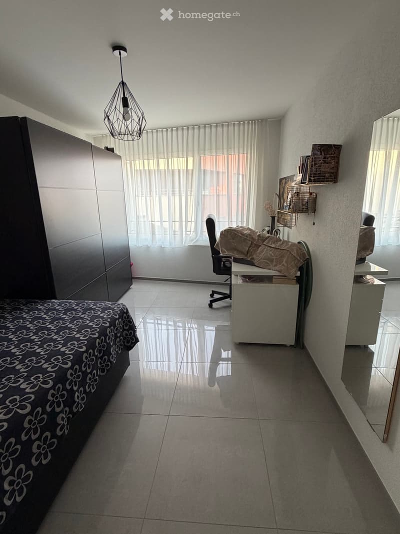 Bedroom with bed, wardrobe, desk, chair, and mirror