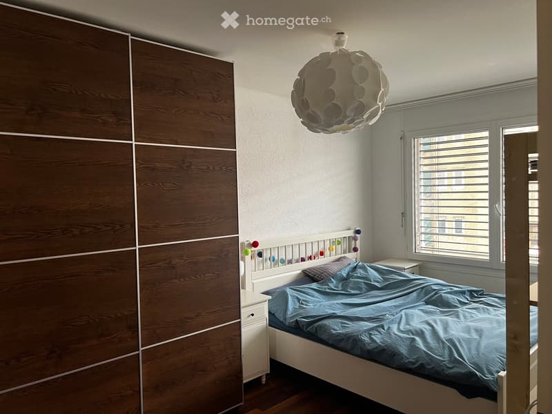 bedroom with bed, nightstand, wardrobe, window with blinds, lamp