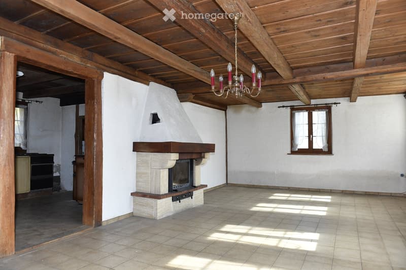 Empty room with fireplace, wooden ceiling, tiled floor, white walls, window with curtains