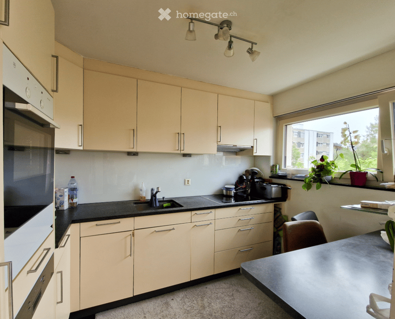 kitchen with oven, sink, cabinets, black countertops, countertop lighting