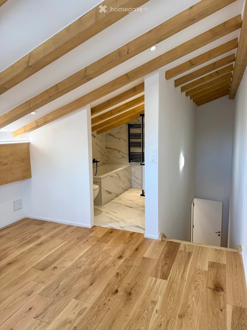 wooden ceiling, wooden floor, white walls, bathroom with bathtub and toilet, white radiator