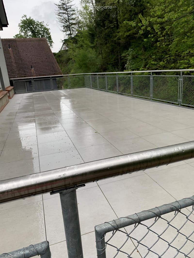 tiled floor, metal railings, metal fence, trees in the background