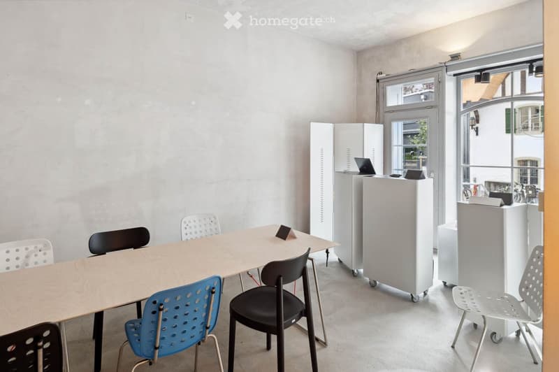 rectangular room with long table, chairs, mobile computer stands, large windows, light ceiling