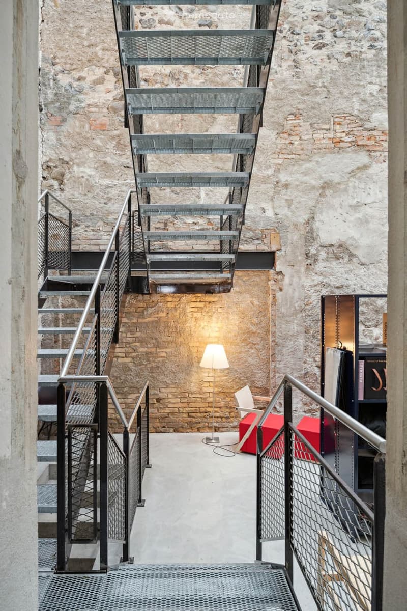 Interior with staircases, brick wall, red bench, lamp