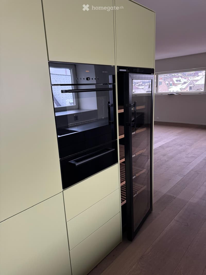 modern kitchen with integrated appliances, wooden floor, large windows