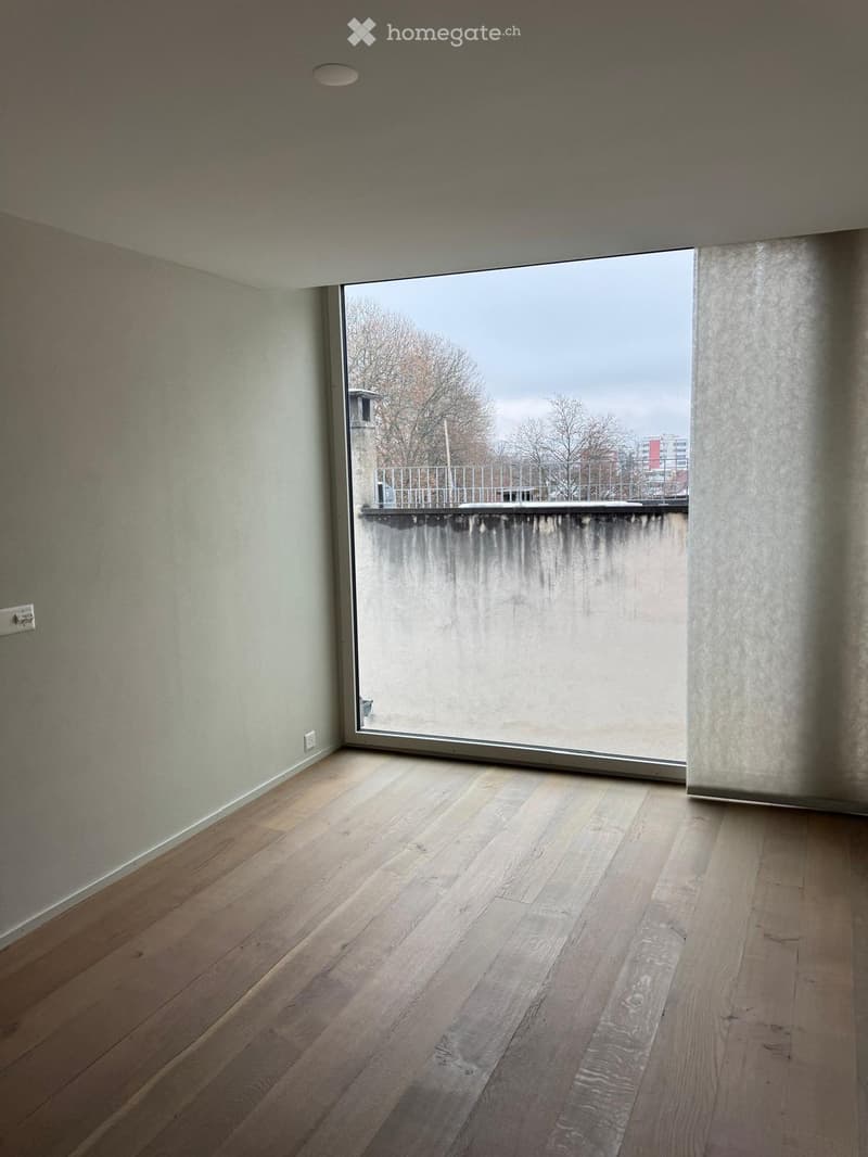 empty room, large window, wooden floor, white walls, power outlet