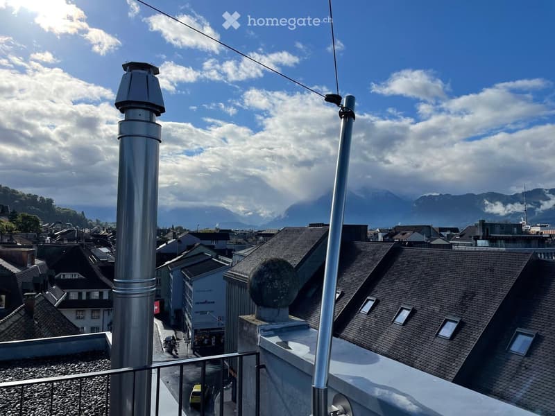 Aerial view of a building with a view of the mountains and the city