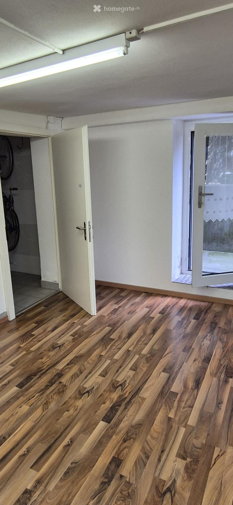 wooden floor, white walls, open door, window, storage closet, bicycles