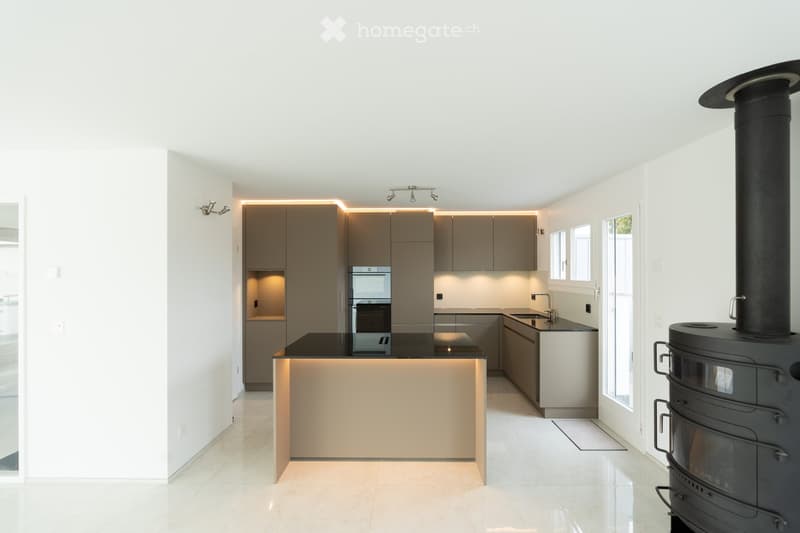 modern kitchen, island with black countertop, built-in oven, central island, modern cabinets, fireplace