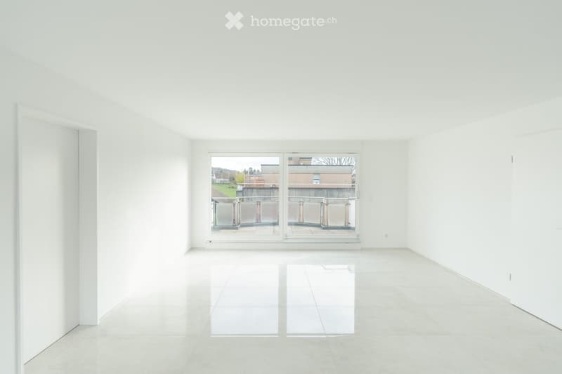 Empty room with white walls, white floor, large glass sliding doors, balcony