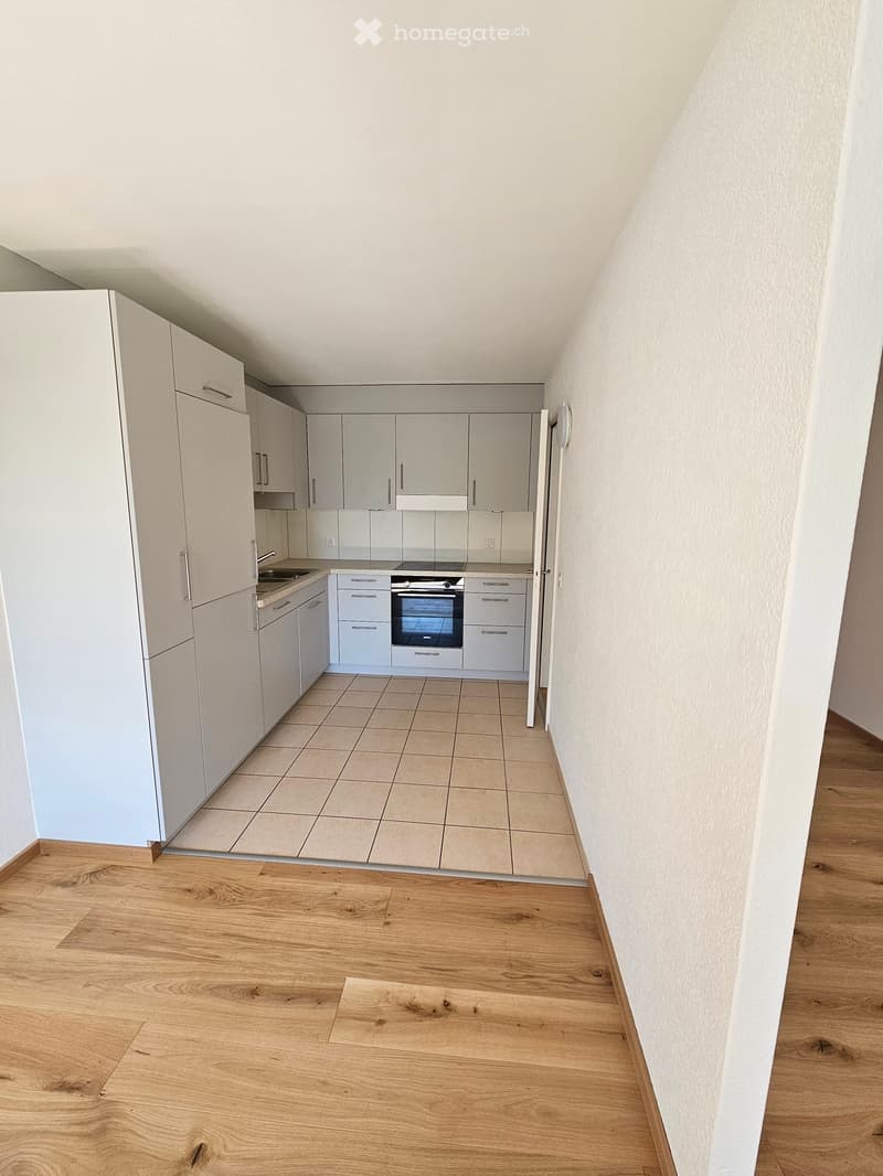 modern kitchen with white cabinets, tiled floor, integrated oven and dishwasher, sink with faucet, power outlets