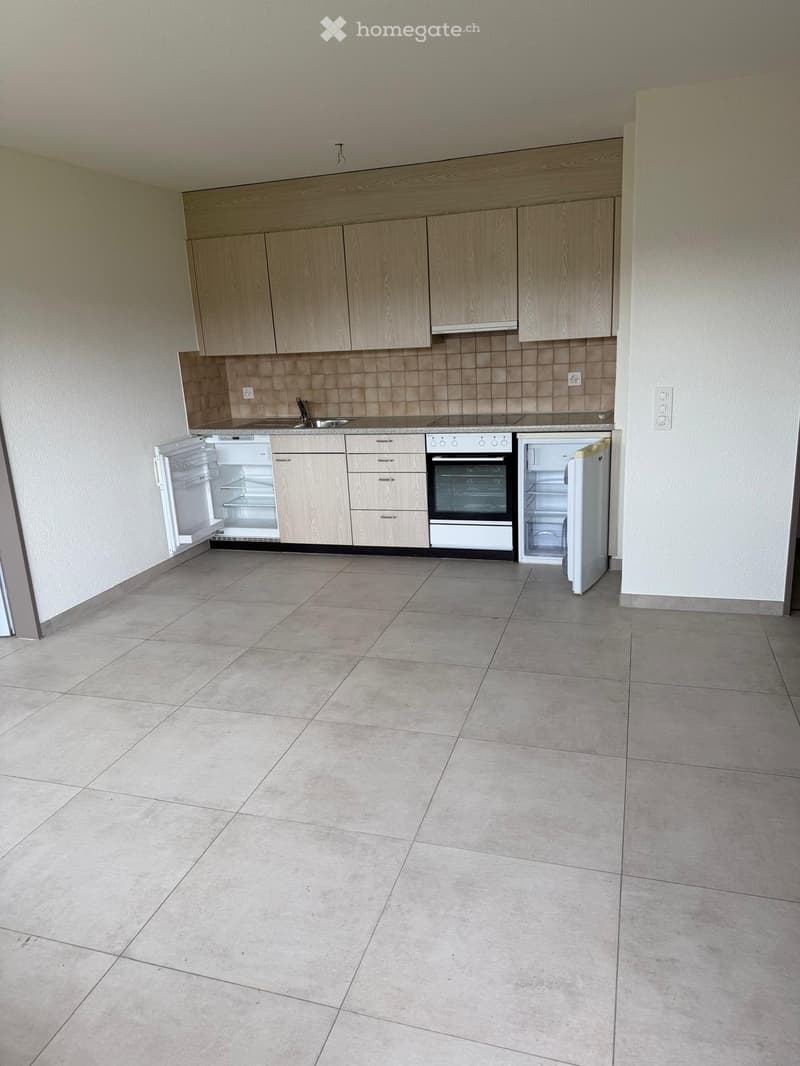 empty kitchen with tiled floor, wooden cabinets, white appliances, open refrigerators