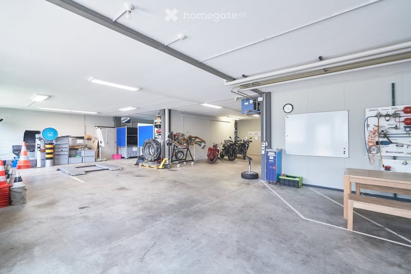 spacious garage with motorcycles, tools, and equipment