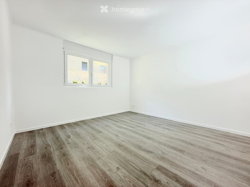Empty room with white walls, wooden floor, and a window.