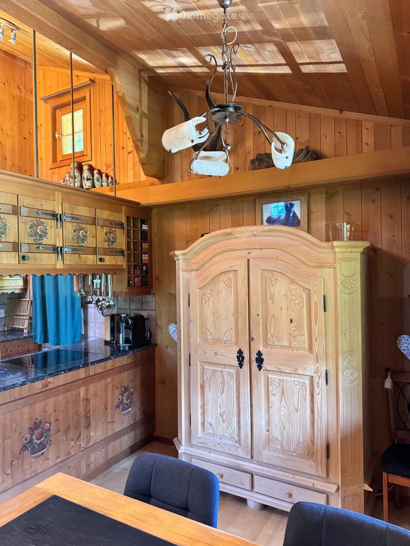 kitchen with wooden cabinets, wooden cupboard, dining table, chairs, chandelier, wooden floor