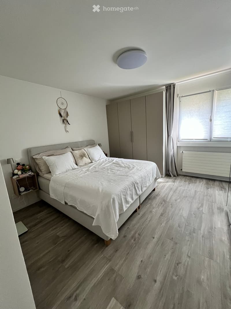 Bedroom with bed, nightstand, wardrobe, and window with curtains