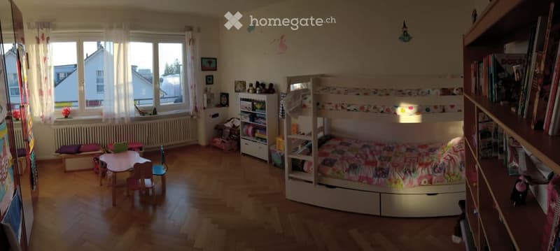 Children's room with wooden floor, bunk bed, desk, chairs, shelves, radiator, windows, curtains