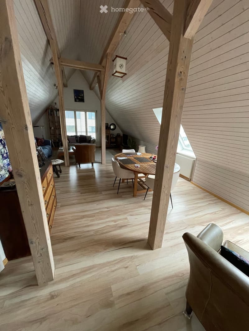 wooden beams, wooden floor, dining table, chairs, sofa, shelves, windows