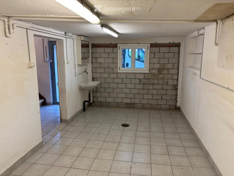 tiled floor, sink, window, pipes on the ceiling