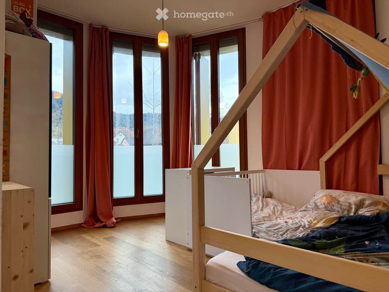 wooden bed, large windows, wooden floor, red curtains, hanging lamp, white storage box
