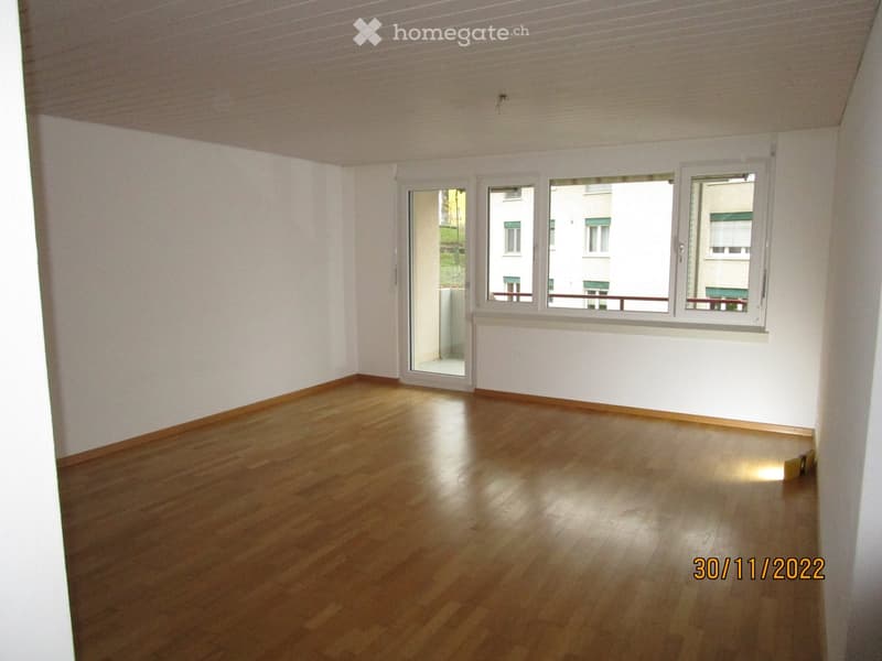 empty room with wooden floor, sliding doors, white walls, windows