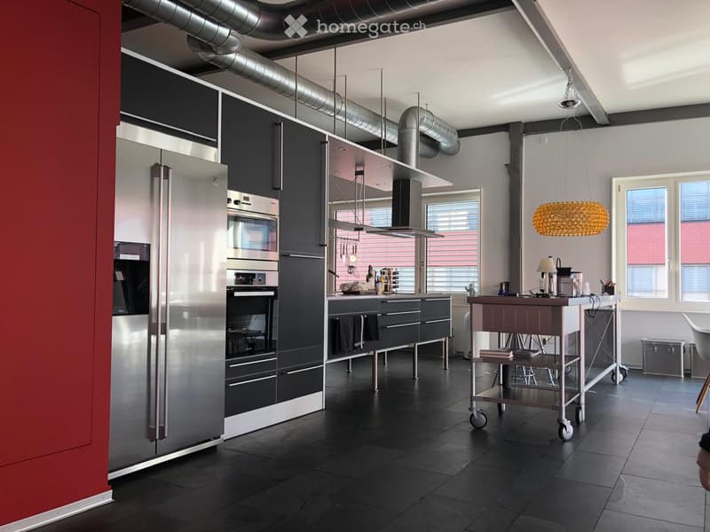 modern kitchen with stainless steel appliances, black tiled floor, gray cabinets, large windows, island with wheels, hanging lamp