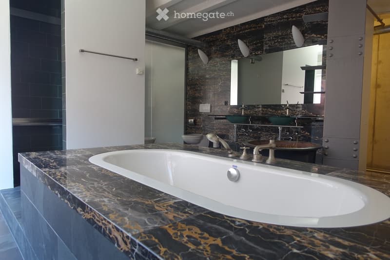 large bathtub, double sink, marble wall, modern fixtures, large mirror
