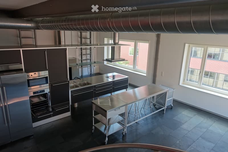 modern kitchen with stainless steel appliances, large windows, stainless steel countertops, stainless steel carts, stainless steel sink, stainless steel faucet