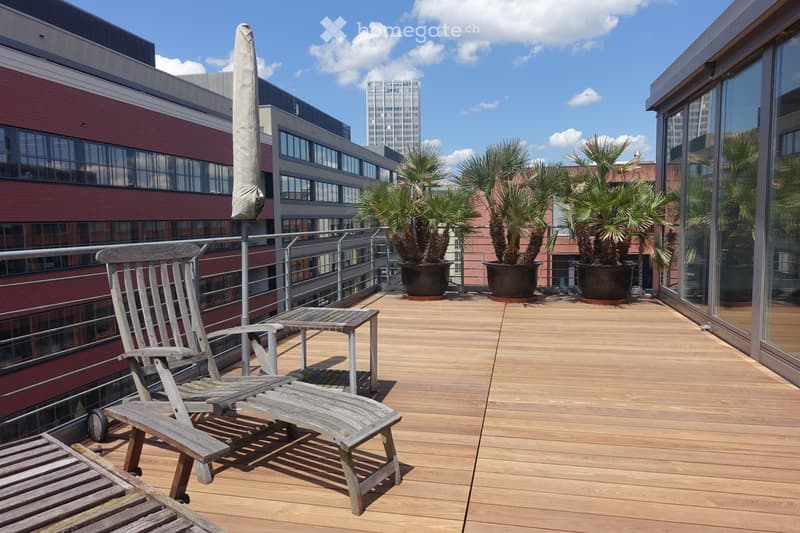 wooden deck, metal railing, wooden chairs, small table, potted plants, city view