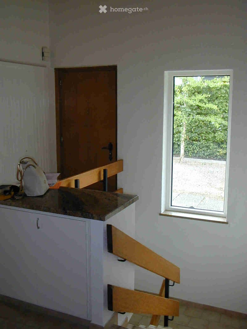 white walls, wooden door, window, wooden stairs, handbag on countertop