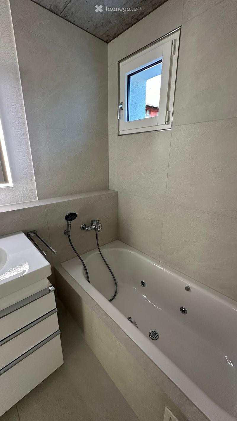 Bathroom with bathtub, sink, and window