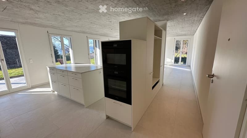 modern kitchen with white cabinets, black oven, large windows, tiled floor