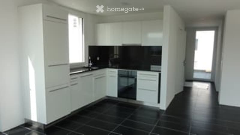 modern kitchen with white cabinets, black tile flooring, central island, dishwasher, washing machine, black countertops
