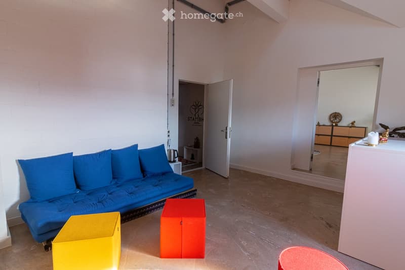 blue sofa, yellow and red stools, white walls, open door, mirror