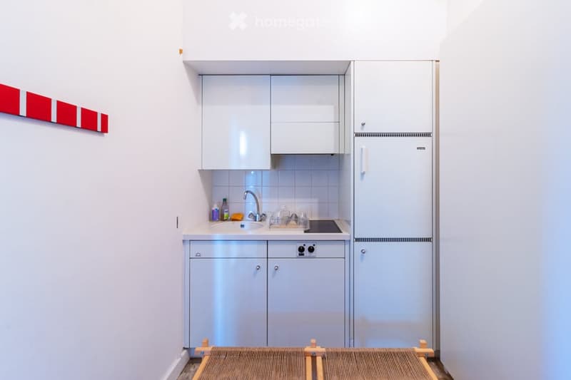 modern kitchen with white cabinets, tiled backsplash, sink, faucet, stove, refrigerator, dishwasher, washing machine