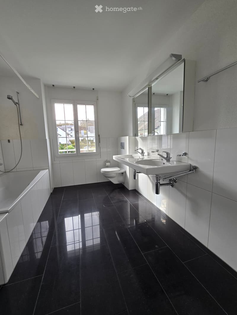 modern bathroom with white tiles, black tiles on the floor, bathtub, two sinks, toilet, shower, mirrors