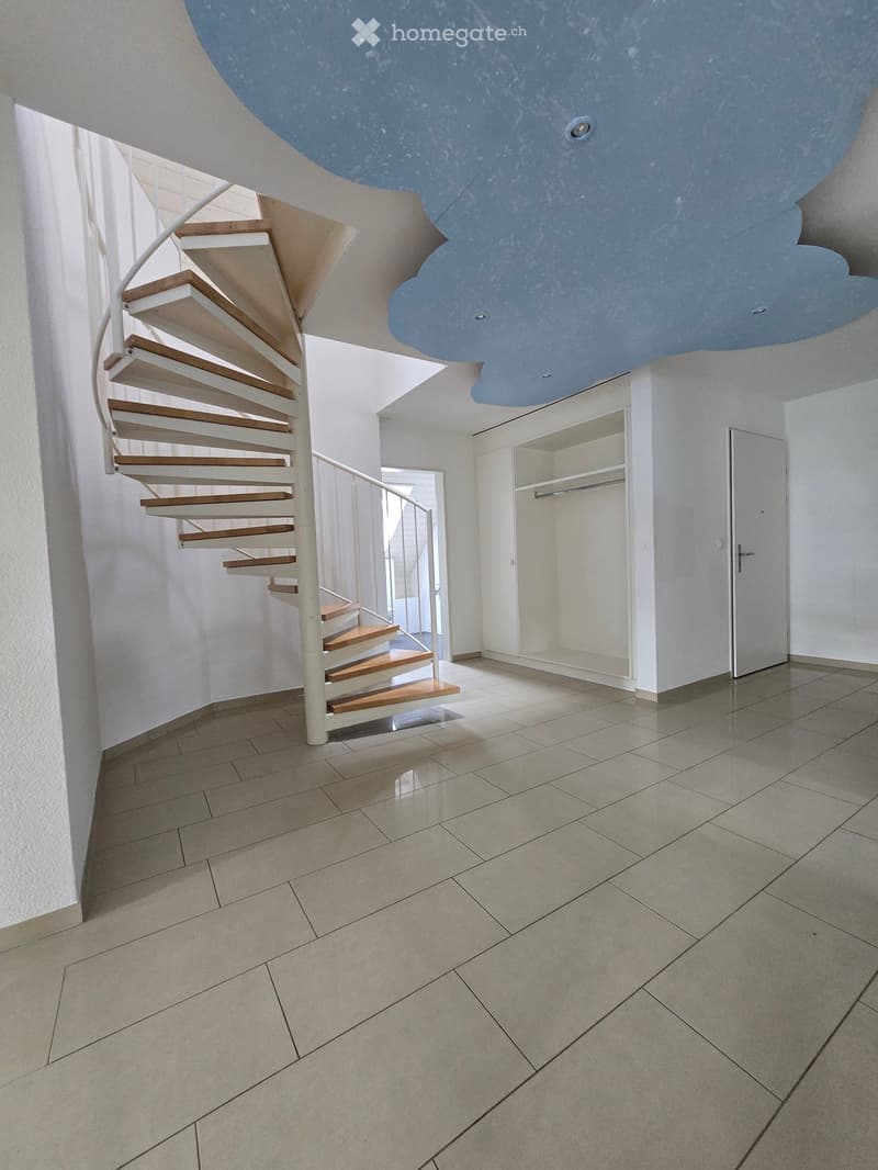 Empty room with spiral staircase, tiled floor, white walls, wardrobe, and a door.