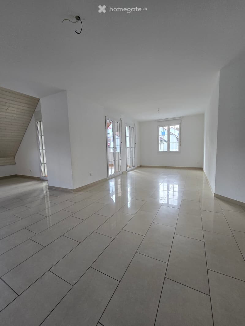 Empty room with white walls, tiled floor, glass doors, and windows