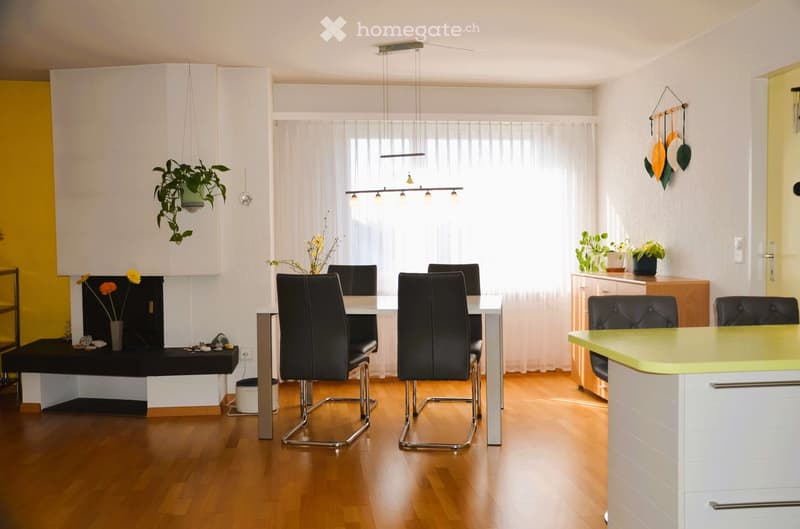 dining table, chairs, fireplace, white walls, wooden floor, plants, cabinets, counter
