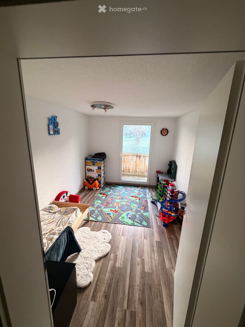 bedroom with bed, rug, toys, and a view of the outside