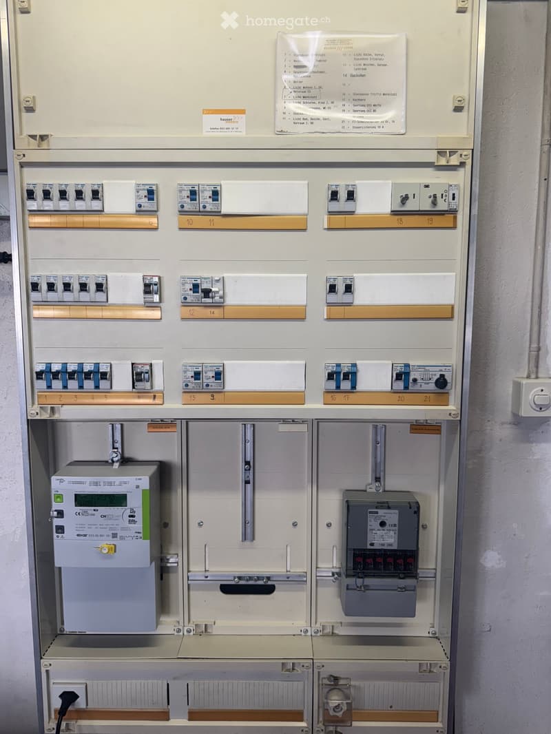 Electrical panel with multiple circuit breakers and meters, labeled with various functions and locations.
