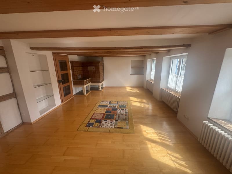 empty room, wooden floor, wooden beams, radiators, rug, shelves, door