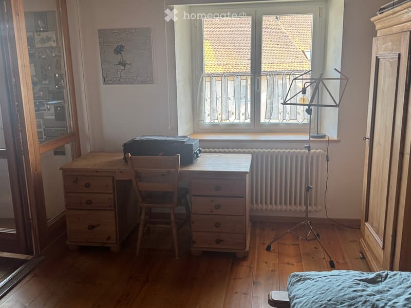 wooden desk, wooden chair, music stand, luggage, radiator, window, wooden floor, wooden cabinet