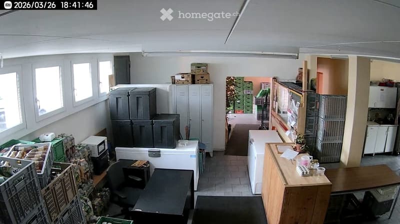 storage room with boxes, cabinets, tables, chairs, appliances, and a refrigerator