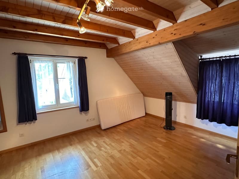 empty room, wooden floor, white walls, wooden beams, window with blue curtains, power outlets, small mirror, white mattress
